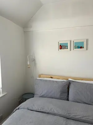 a bedroom with a bed and two pictures on the wall at The Barn in Saxmundham