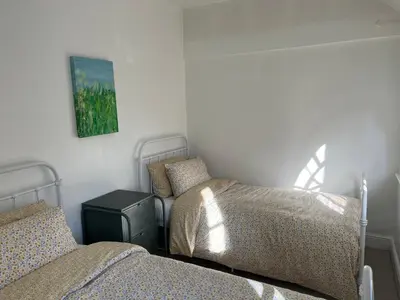 a bedroom with two beds and a picture on the wall at The Barn in Saxmundham