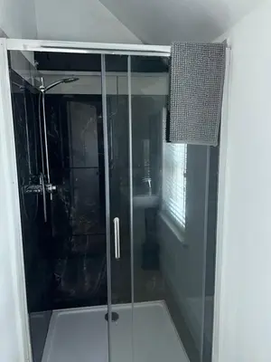 a shower with a glass door in a bathroom at The Barn in Saxmundham