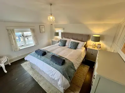 a bedroom with a large bed with two pillows at Cosy Coastal 2-Bedroom Cottage with Hot Tub and Log Burner in West Mersea