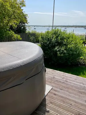a mattress sitting on top of a wooden deck at Cosy Coastal 2-Bedroom Cottage with Hot Tub and Log Burner in West Mersea