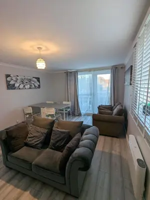 a living room with a couch and a table at A&A Apartment Basildon in Nevendon
