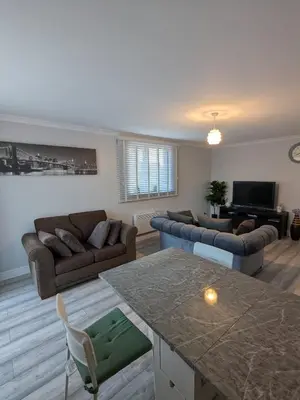 a living room with two couches and a table at A&A Apartment Basildon in Nevendon