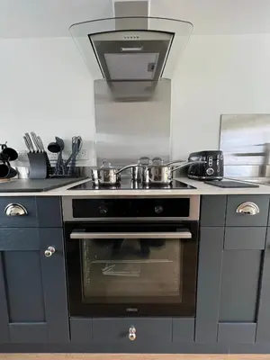 a kitchen with a stove with pots and pans on it at Dolls House Cottage in Hilborough