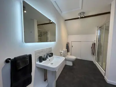 a bathroom with a sink and a toilet and a mirror at Dolls House Cottage in Hilborough