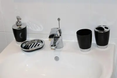 a sink with three cups and a faucet on it at Lovely Modern Apartment Close to Town Centre in Lexden