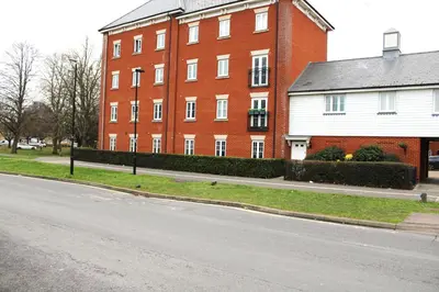 a large red brick building on the side of a street at Lovely Modern Apartment Close to Town Centre in Lexden
