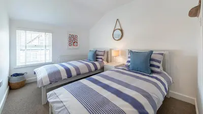 a bedroom with two beds and a window at Sea Breeze Apartment in Walton-on-the-Naze