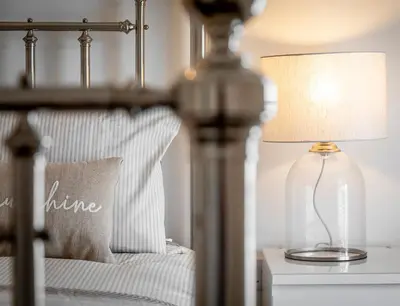 a lamp on a table next to a bed at Sea Breeze Apartment in Walton-on-the-Naze