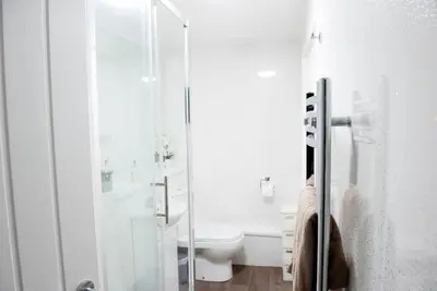 a bathroom with a toilet and a glass shower at King's - Spacious Central Ground Floor Apartment in Cambridge