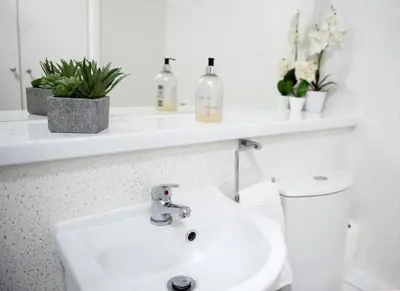 a white bathroom with a sink and a toilet at King's - Spacious Central Ground Floor Apartment in Cambridge