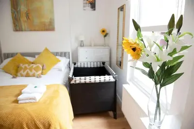 a bedroom with a bed and a vase of flowers at King's - Spacious Central Ground Floor Apartment in Cambridge