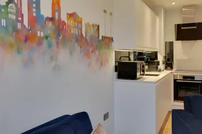 a living room with a painting on the wall at New London Life Executive Apartments in Chelmsford