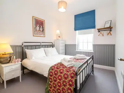 a bedroom with a bed and a table with towels on it at Ebenezer Chapel in Saxmundham