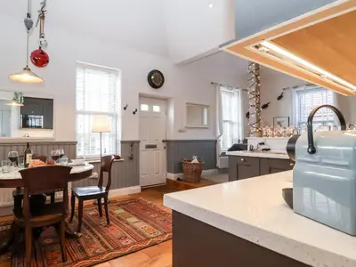 a kitchen with a table and chairs in a room at Ebenezer Chapel in Saxmundham