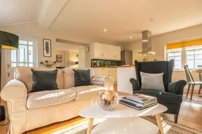 a living room with a couch and a table at Bell Tower Cottage in Middleton
