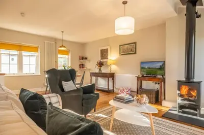 a living room with a couch and a fireplace at Bell Tower Cottage in Middleton