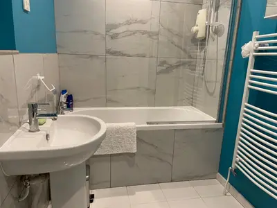 a bathroom with a sink and a shower and a tub at Silver Lodge Guest House in Mildenhall