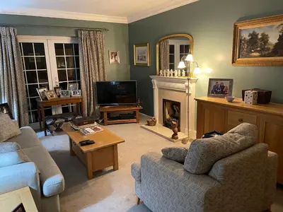 a living room with a couch and a fireplace at Silver Lodge Guest House in Mildenhall
