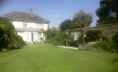 a house with a large lawn in front of it at Silver Lodge Guest House in Mildenhall