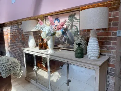 a table with two vases and two lamps on it at Lynford Holiday Cottages nestled in the heart of Thetford Forest in Mundford