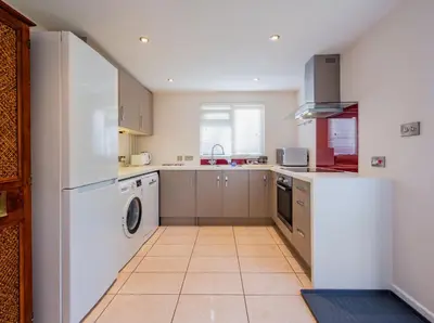 a kitchen with a white refrigerator and a dishwasher at The Garden Cottage, Wenhaston, Suffolk, near coast in Halesworth