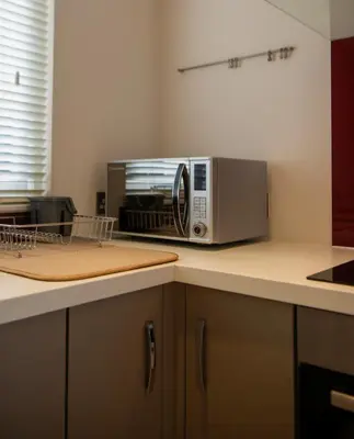 a microwave oven sitting on top of a kitchen counter at The Garden Cottage, Wenhaston, Suffolk, near coast in Halesworth