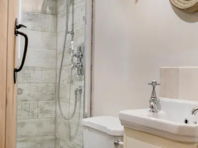 a bathroom with a shower and a toilet and a sink at Hill Farm in Blyford