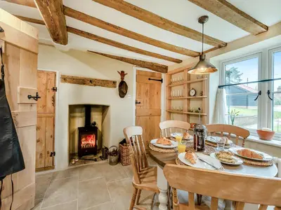 a dining room with a table and a fireplace at Hill Farm in Blyford