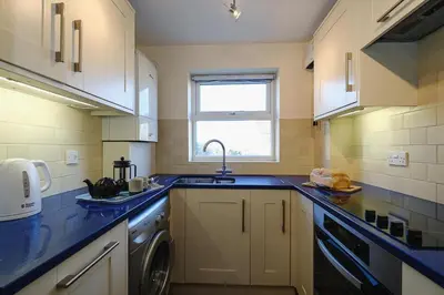 a kitchen with a sink and a washing machine at 1 Coastguard Court in Aldeburgh