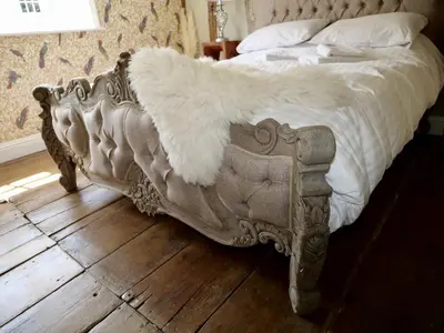 a bed with a white blanket on top of it at Luxury 9 Bed Manor House Hot Tub Cinema Room SkyTV in Saffron Walden