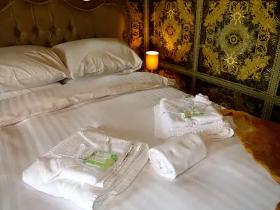 a bed with towels and towels on it at Deluxe 4 5 Bed Hot Tub Cinema Room 15 in Saffron Walden
