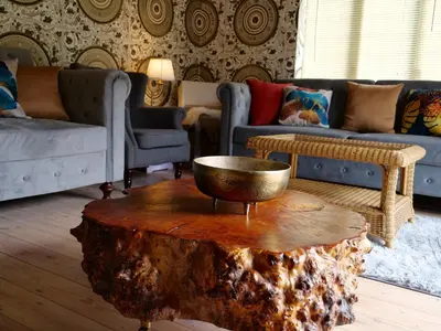 a living room with a tree stump coffee table at Deluxe 4 5 Bed Hot Tub Cinema Room 15 in Saffron Walden