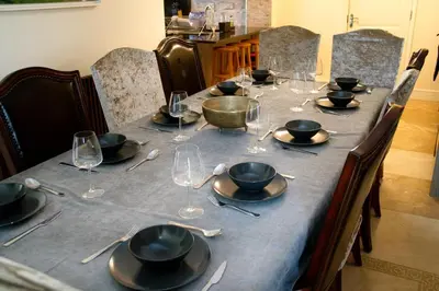 a long table with plates and wine glasses on it at Deluxe 4 5 Bed Hot Tub Cinema Room 15 in Saffron Walden