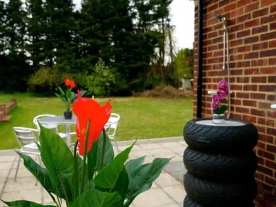 a stack of tires sitting next to a table with flowers at Deluxe 4 5 Bed Hot Tub Cinema Room 15 in Saffron Walden