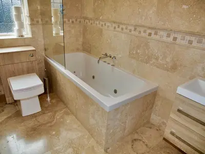a bathroom with a bath tub and a toilet at Deluxe 4 5 Bed Hot Tub Cinema Room 15 in Saffron Walden