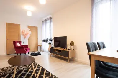 a living room with a tv and two chairs and a table at Modern Pet-Friendly Apartment in Cambridge with Garden & Parking in Chesterton