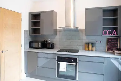 a kitchen with a counter with a stove top oven at Modern Pet-Friendly Apartment in Cambridge with Garden & Parking in Chesterton