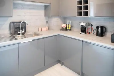 a kitchen with gray cabinets and a sink at Modern Pet-Friendly Apartment in Cambridge with Garden & Parking in Chesterton