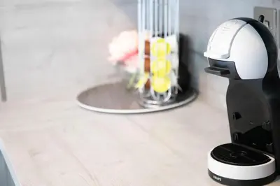 a black and white robot sitting on a counter with flowers at Modern Pet-Friendly Apartment in Cambridge with Garden & Parking in Chesterton