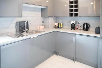 a kitchen with gray cabinets and a sink at Modern Pet-Friendly Apartment in Cambridge with Garden & Parking in Chesterton