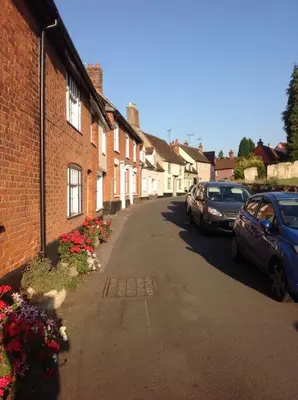 a street with houses and cars parked on the street at Acacia Cottage in Halstead