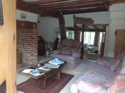 a living room with a couch and a table at Acacia Cottage in Halstead