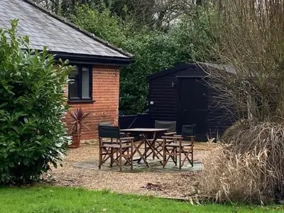 a picnic table and chairs in a yard at Wood Farm Barn in Laxfield