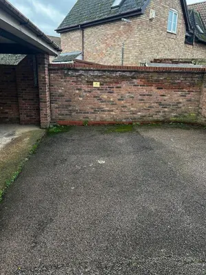 a brick wall next to a driveway in front of a house at Victoria Gardens in Colchester