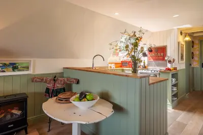 a kitchen with a table with a bowl of fruit on it at Vibrant rural hideaway - Aspen Loft in Sudbury