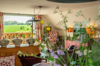 a living room with a view of a green field at Vibrant rural hideaway - Aspen Loft in Sudbury