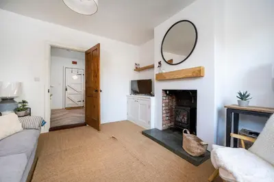 a living room with a fireplace and a mirror at 3 Lower Falkland Cottage Long Melford in Sudbury