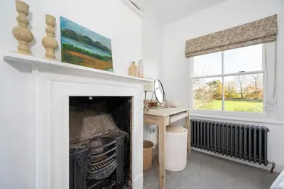 a living room with a fireplace and a window at 3 Lower Falkland Cottage Long Melford in Sudbury