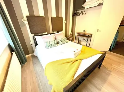 a bedroom with a large white bed with a yellow blanket at Serene and Cozy 1-Bedroom House with Parking in Cambridge